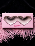 Pink heart-shaped box containing false eyelashes on a black background with pink feathers. Reusable Human Hair Lashes.